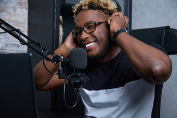 A young smiling blogger records a training lecture for his audience on social media. In the frame,...