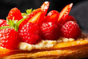 Delicious mixed berry Danish with custard, raspberries, and strawberries dusted with icing sugar and decorated with mint leaves.