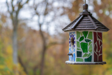 Beautiful decorative birdhouse infront of the onset of autumn