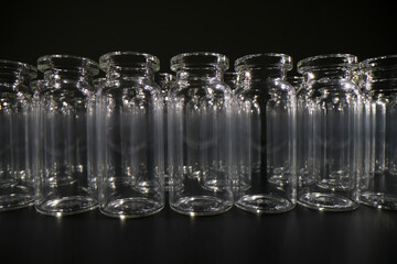 Empty vials for vaccines stand in row on dark background