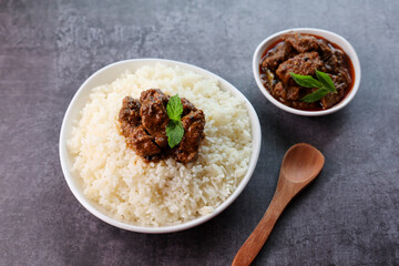 Mutton or Beef biryani Ghee rice. Gosht or lamb biryani Hyderabadi Dum biriyani with raita yoghurt dip. Special occasion festival food for Ramadan Eid Easter Christmas Kerala Hyderabad India.