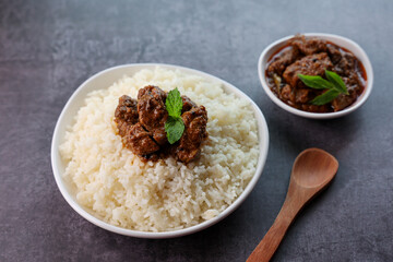 Mutton or Beef biryani Ghee rice. Gosht or lamb biryani Hyderabadi Dum biriyani with raita yoghurt dip. Special occasion festival food for Ramadan Eid Easter Christmas Kerala Hyderabad India.