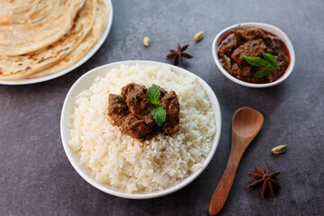 Mutton or Beef biryani Ghee rice. Gosht or lamb biryani Hyderabadi Dum biriyani with raita yoghurt dip. Special occasion festival food for Ramadan Eid Easter Christmas Kerala Hyderabad India.