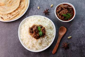 Mutton or Beef biryani Ghee rice. Gosht or lamb biryani Hyderabadi Dum biriyani with raita yoghurt dip. Special occasion festival food for Ramadan Eid Easter Christmas Kerala Hyderabad India.