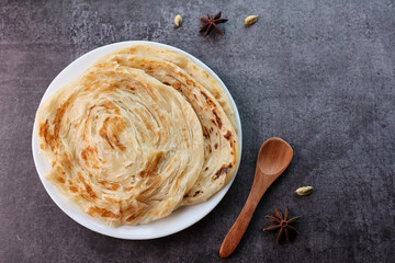 Kerala parathas porotta roti parotta barotta naan layered flatbread made from maida or whole wheat flour. Eat with spicy Asian chicken or beef or egg curry gravy. breakfast dish. Indian food.