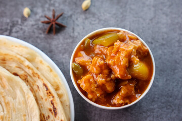 Chilli chicken with Kerala parathas porotta roti parotta barotta naan layered flatbread made from maida whole wheat flour. Eat with spicy Asian chicken beef egg curry gravy. Indian food.
