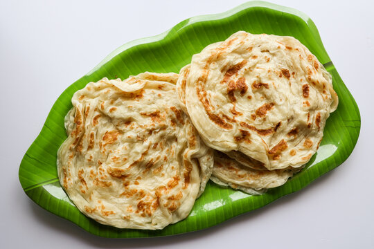 Kerala parathas porotta roti parotta barotta naan layered flatbread made from maida or whole wheat flour. Eat with spicy Asian chicken or beef or egg curry gravy. breakfast dish. Indian food.
