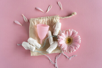 Tampons and menstrual cup on pink background. Menstrual cup vs tampons. Zero waste and eco living concept