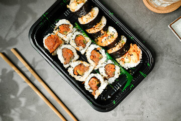 sushi roll in take away or to go box for food delivery concept.