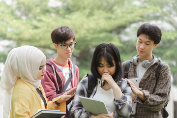 A friend is comforting a sad young Asian university student who failed an exam outdoors on campus. Student, mental health and depression with anxiety, burnout and sad for exam results, fail or mistake