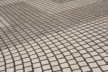 road surface Small square stones arranged together to form a beautiful pattern.
