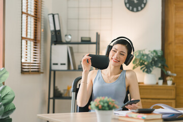 Portrait of a happy millennial Asian businesswoman working remotely from her home office. Warm tone