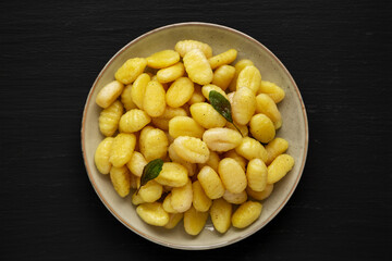 Homemade Easy Potato Gnocchi on a Plate on a black background, top view. Flat lay, overhead, from above.