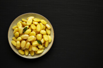 Homemade Easy Potato Gnocchi on a Plate on a black background, top view. Flat lay, overhead, from above.