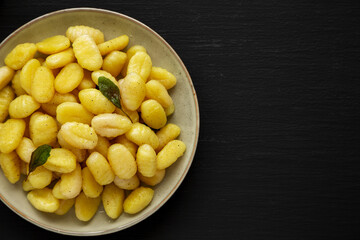 Homemade Easy Potato Gnocchi on a Plate on a black background, top view. Flat lay, overhead, from above. Copy space.
