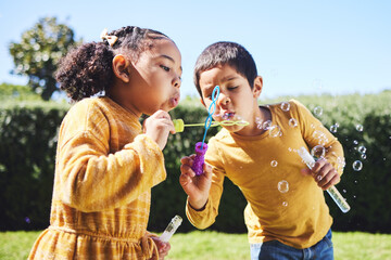 Playing, garden and children blowing bubbles for entertainment, weekend and fun activity together. Recreation, outdoors and siblings with a bubble toy for leisure, childhood and enjoyment in summer - Powered by Adobe