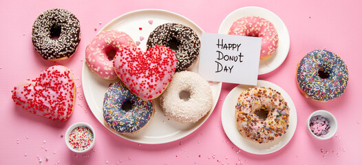Tasty donuts on pink background. National donuts day.