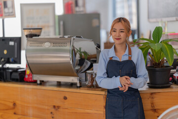 Fototapeta na wymiar Portrait of Startup successful small Asian business owner in coffee shop. Beautiful Asian woman barista cafe owner.