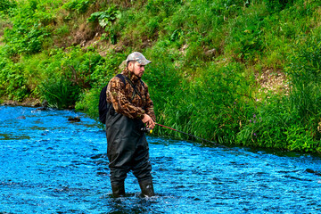 A fisherman catches fish while standing in the water