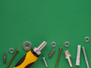 Green background with hand tools, metal fasteners and fittings. Industrial design with copy space. Tools, worker concept.