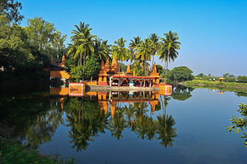 Temple on the lake. Hindu Temple. Palm trees and lake. Blue Sky. Lovely Water reflection. Maharashta. india