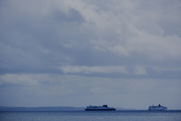 Passenger pax cargo car roro ro-ro ferry boat vessel cruiseship cruise ship liner at sea with sky and coastline