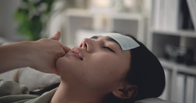 Footage of Sick young Asian woman in warm blanket shiver tremble with cold with cooler gel on her head on sofa at living room. People, health care and lifestyle concepts.