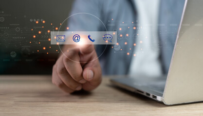 Contact us or the customer support hotline people connect. Businessman using a laptop and touching on virtual screen contact icons of email, address, phone, and live chat