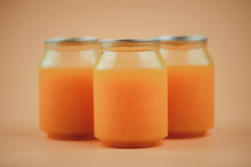 Fototapeta na wymiar Plastic organic juice bottles with fresh juice on a orange background