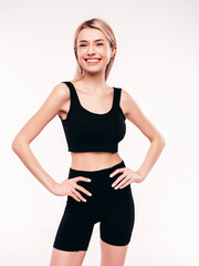 Fototapeta premium Young beautiful smiling blond female in black cycling shorts clothes. Sexy carefree woman posing on white background in studio. Positive model having fun indoors. Cheerful and happy