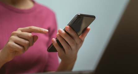 Hand holding smartphone with using social media on internet on table.