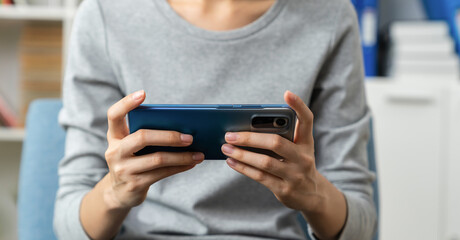 Hand holding smartphone with using social media on internet on table.