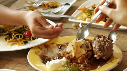 4K footage close-up front view, Many people use spoons to scoop ice cream on dessert plates.