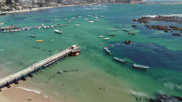 Aerial orbit establishing of boats parked at the dock of Pejerrey beach, Algarrobo, Chile.