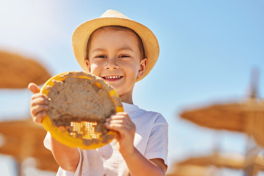 Image of a young boy playing with sand on the beach