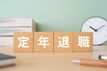 定年退職と書かれたブロックが置かれたデスク