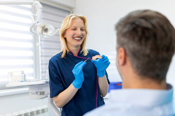 Dentist showing dental plaster mold to the patient. Dentist doctor showing jaw model at dental clinic, dental care concept. Dental care concept.