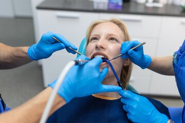 Close-up of a dental drill procedure at dentist approaching a patient with dental instruments held...