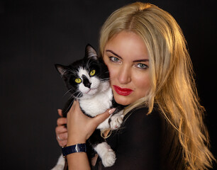 Portrait of a girl with a cat on a black background