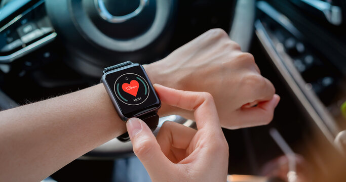 Woman sitting in a private car and hand wearing a smartwatch and checking active lifestyle. - Powered by Adobe
