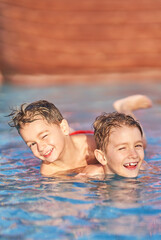 Fototapeta na wymiar Picture of brothers playing in outdoor aqua park pool