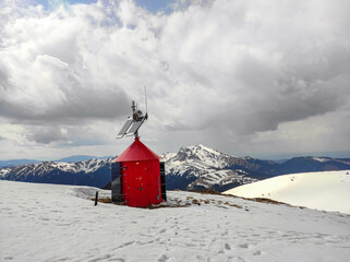 Refuge shelter up in the Carpathian Mountains of Romania , equipped with solar panels and meteorological recording equipment , snowy peaks in the background , winter scenery