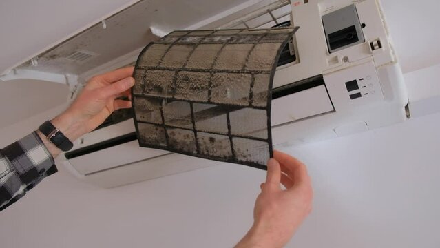 Air conditioner filter dusty. Preparation for maintenance and cleaning.