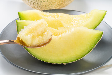 Golden spoon with Crown Musk Melon on white background, Shizuoka Crown Melon Yama Grade on isolate on white background.