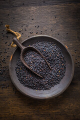 Beluga lentils on wooden background. Black lentils in bowl
