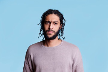 Arab confused man looking at camera with uncertain emotions. Young arabian person with black...