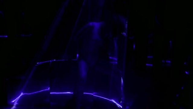 passionate erotic dance of beautiful slender woman in nightclub with laser rays, gorgeous silhouette