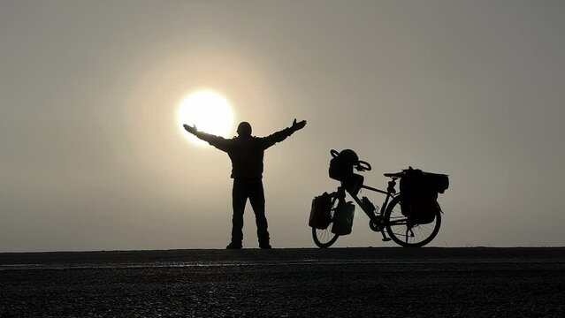 the person taking a break with his bike cannot resist the lure of the sun