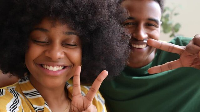 Smiling black cuple taking selfie on smartphone