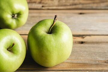 Beautiful green apples on a wooden background.